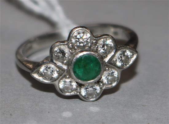 A platinum, emerald and diamond cluster ring, size M.